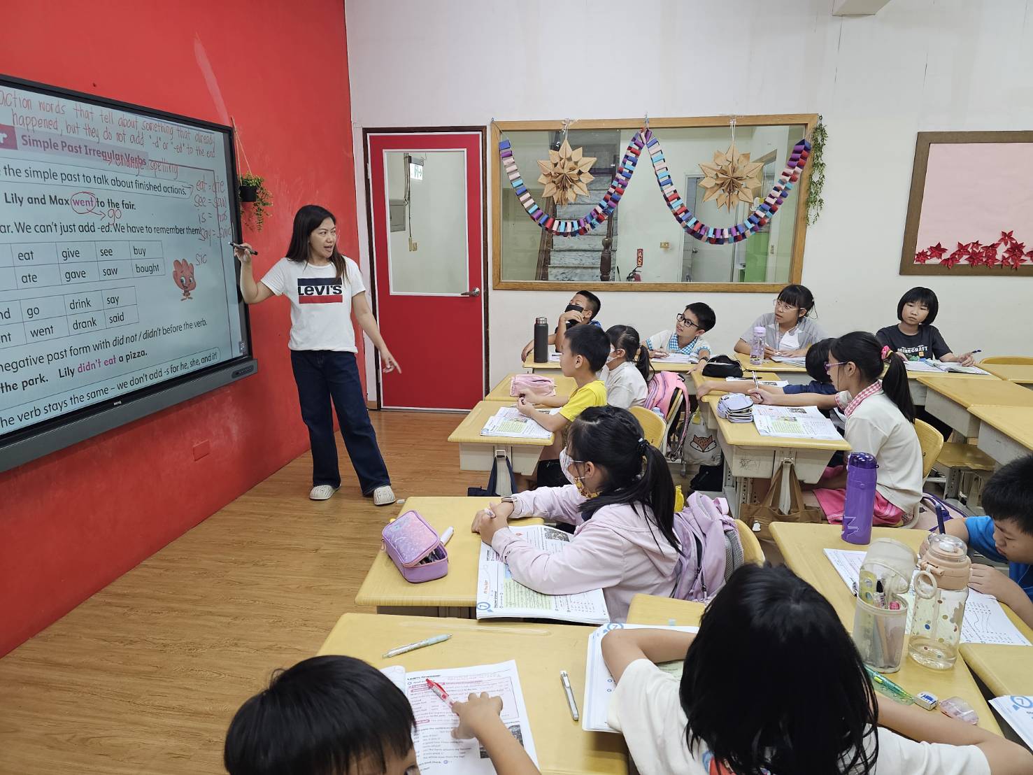 兒童美語班學生跟隨老師進行電子白板英文教學